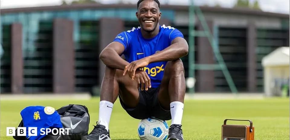 Futbolchi o'yin maydonida kulib o'tirgan