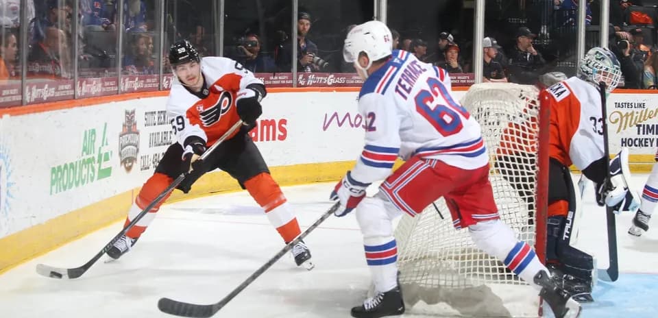 Flyers player skating with puck near goal