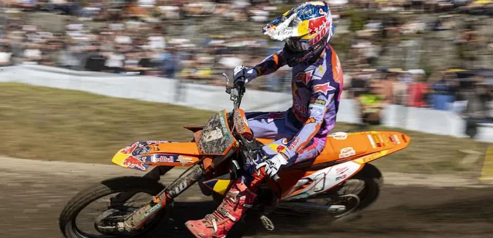 Motocross rider navigating a turn on dirt track