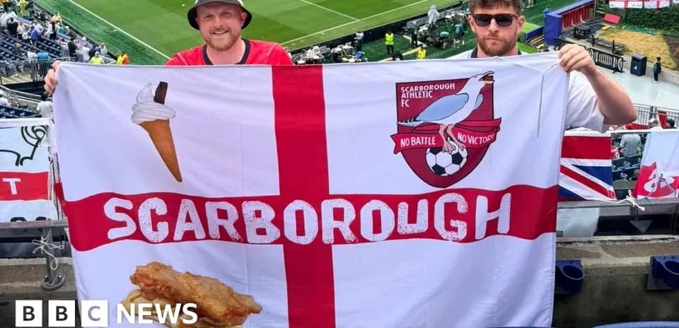 Two fans holding Scarborough Athletic FC flag