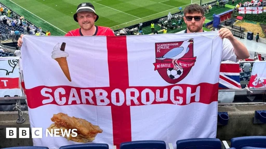 Two fans holding Scarborough Athletic FC flag