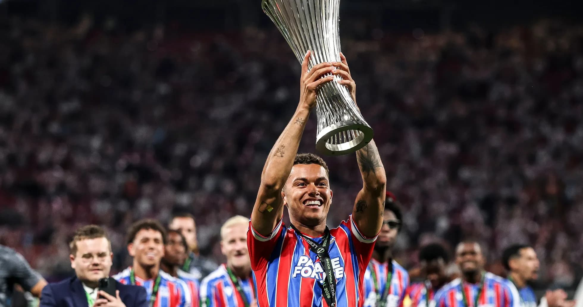 Futbolchi kubokni ko'tarib turib, g'alaba quvonchi