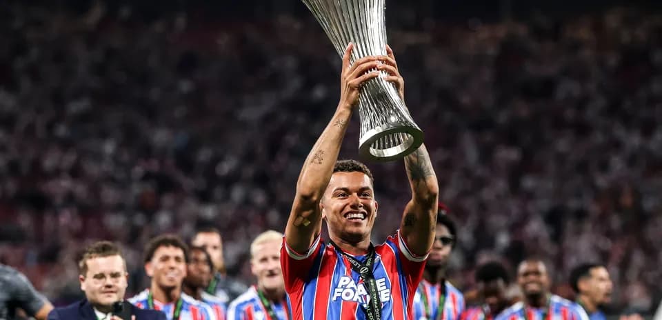 Futbolchi kubokni ko'tarib turib, g'alaba quvonchi
