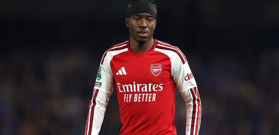 Futbolchi Arsenal formasi bilan maydonda harakatda