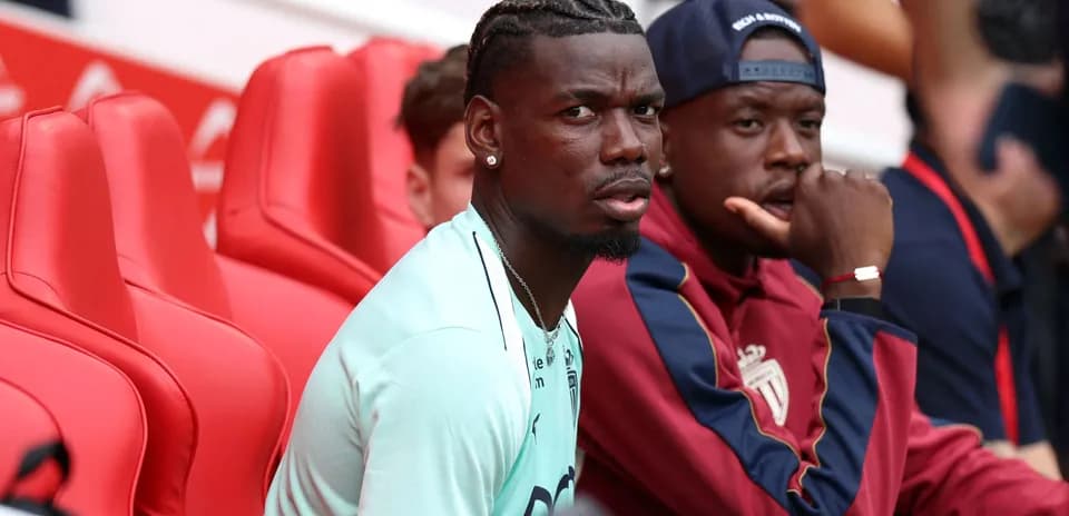 Futbolchilar benchda o'tirgan holda suhbatlashmoqda