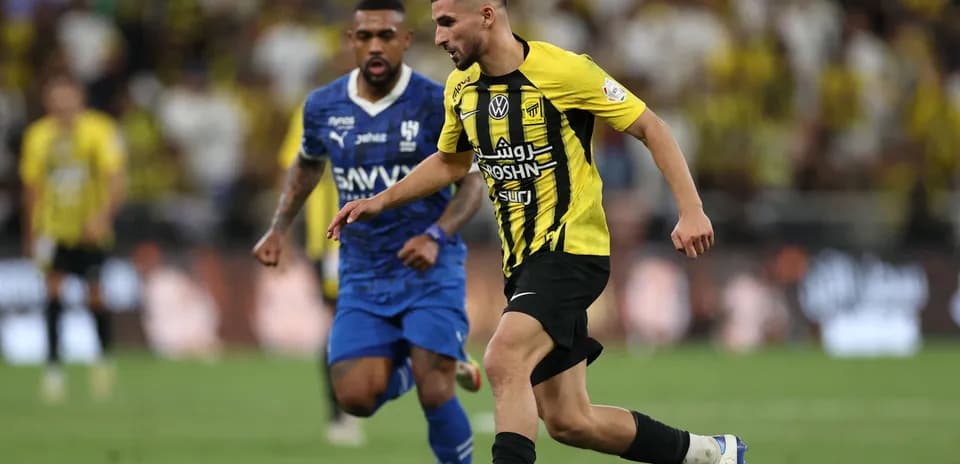 Ittihad player dribbling past Al Hilal opponent