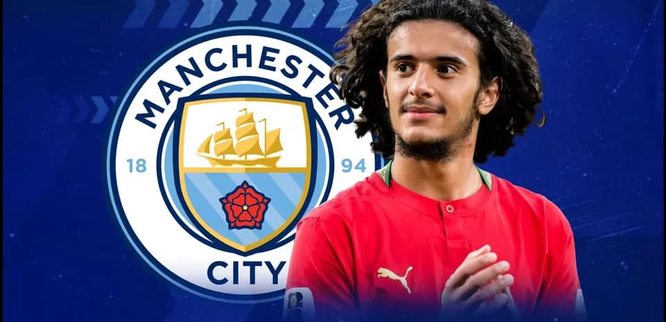 Futbolchi Manchester City logosi oldida turibdi