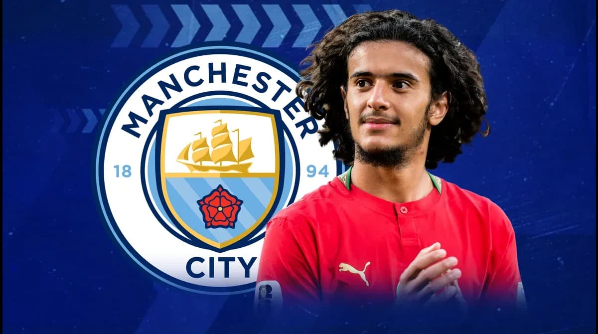 Futbolchi Manchester City logosi oldida turibdi