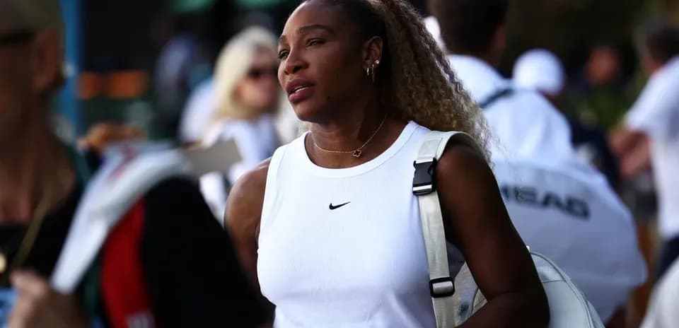 Tennis player walking with bag in crowd