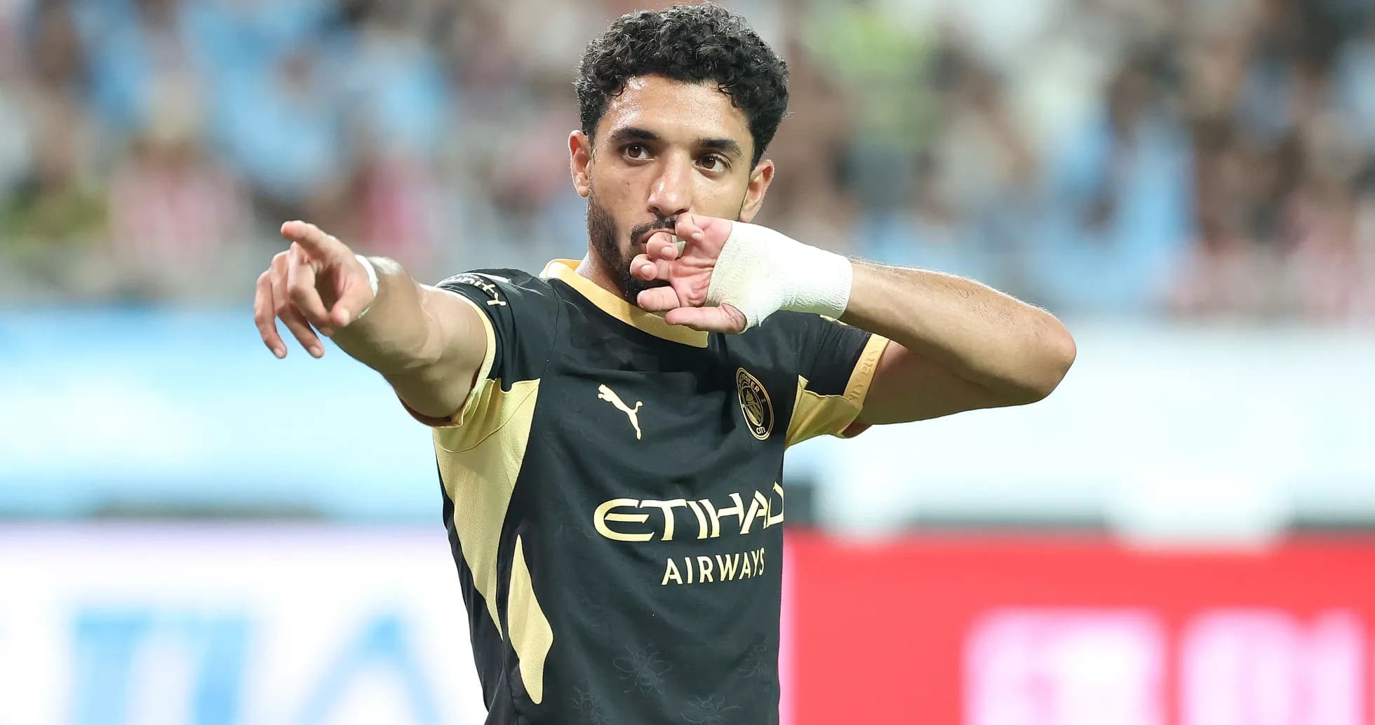 Futbolchi maydonda jamoasiga ishora qilmoqda