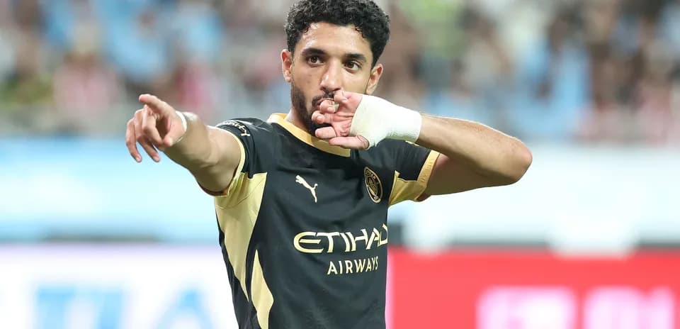 Futbolchi maydonda jamoasiga ishora qilmoqda