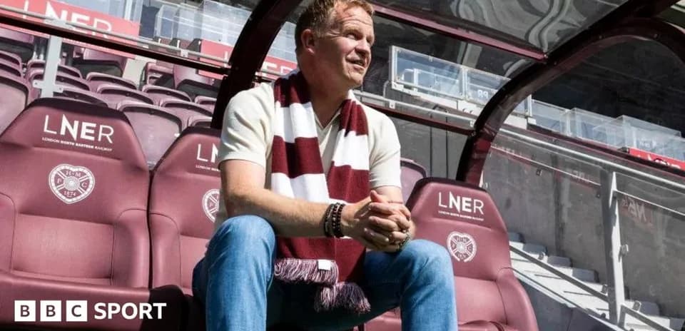 Coach sitting on bench at football stadium