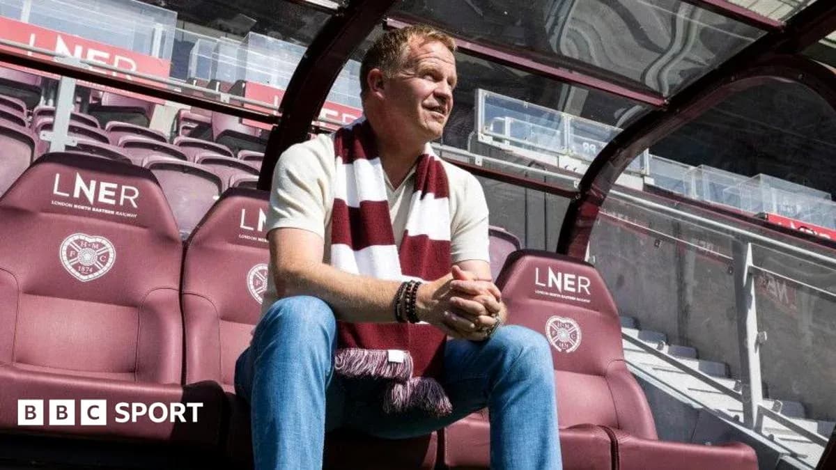 Coach sitting on bench at football stadium