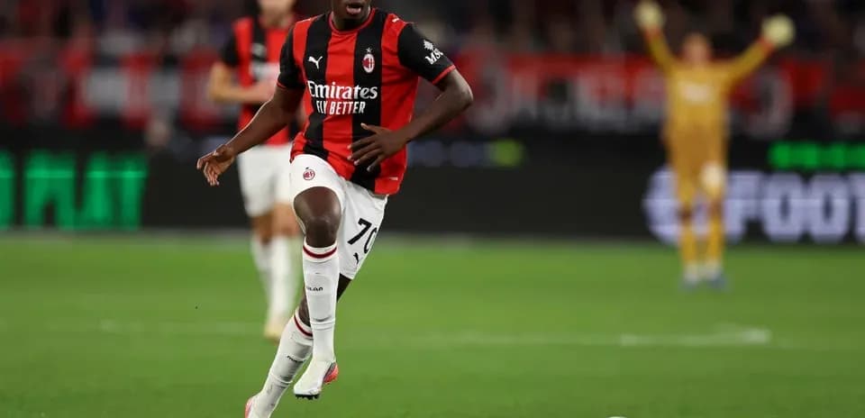 Futbolchi Milan formasi bilan to'pni olib bormoqda
