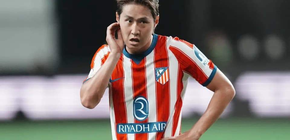 Futbolchi o'yin davomida qo'lini quloq tomon tutmoqda