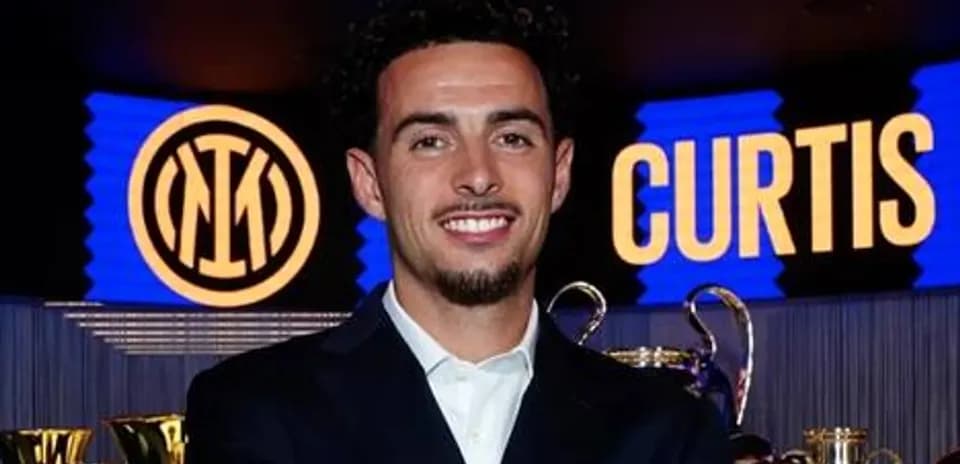 Futbolchi mukofotlar oldida tabassum qilmoqda