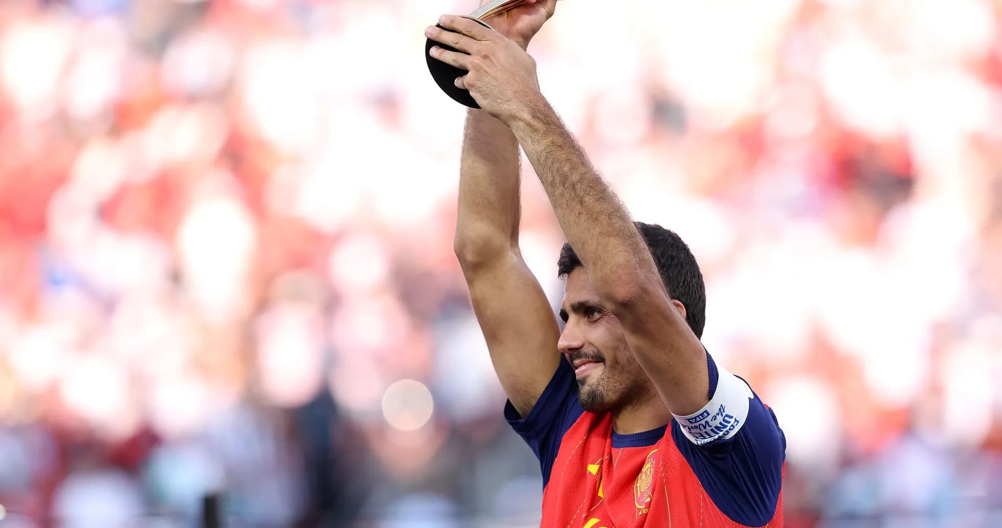 Futbolchi mukofotni ko'tarib turib, maydonda