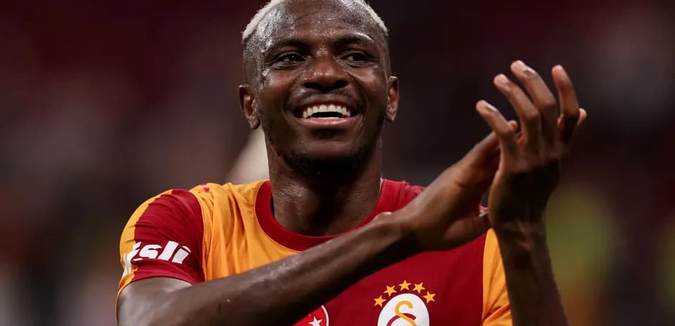 Futbolchi olovda qo'llarini tepaga ko'tarib turgan