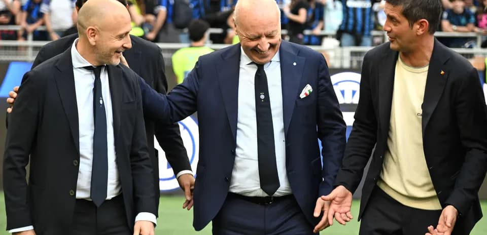Coaches interacting on the pitch before the match