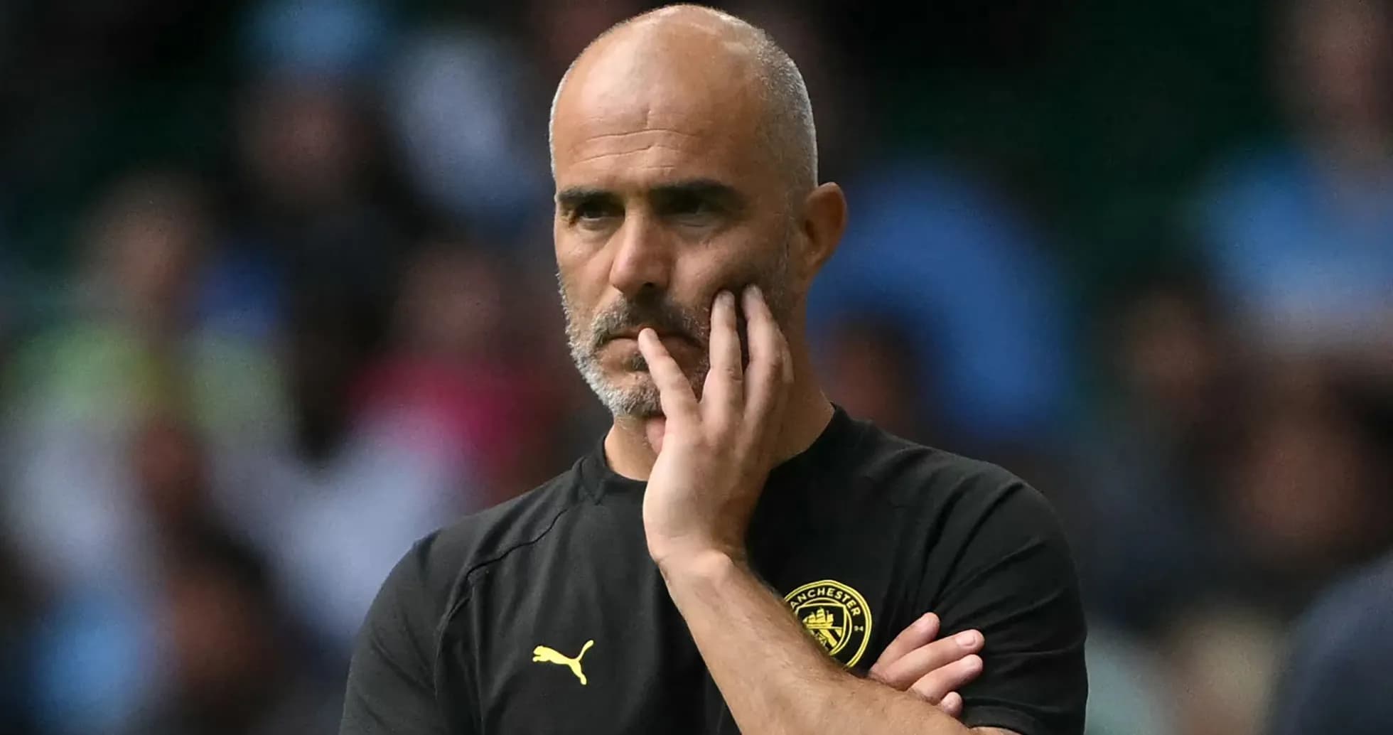 Football coach observing match with thoughtful expression