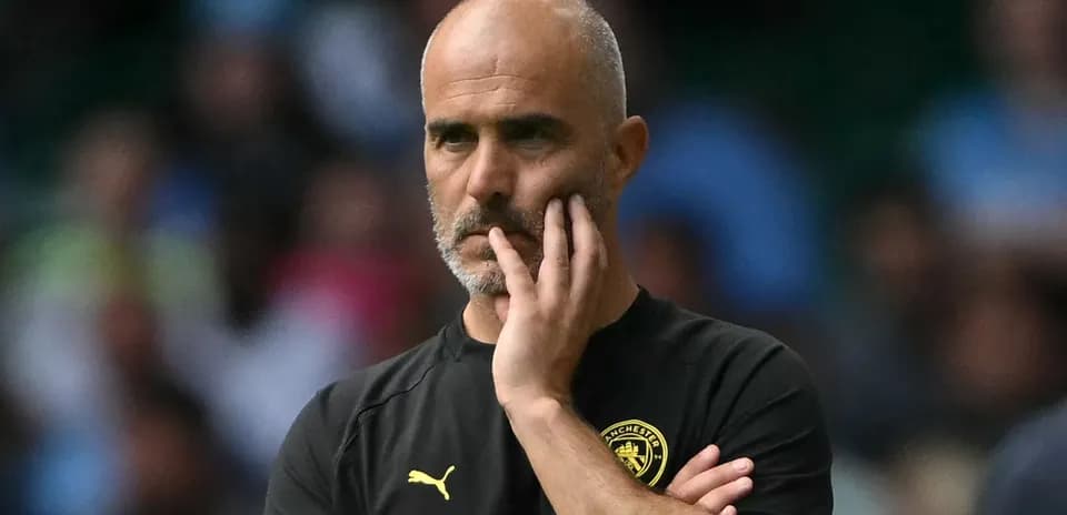 Football coach observing match with thoughtful expression
