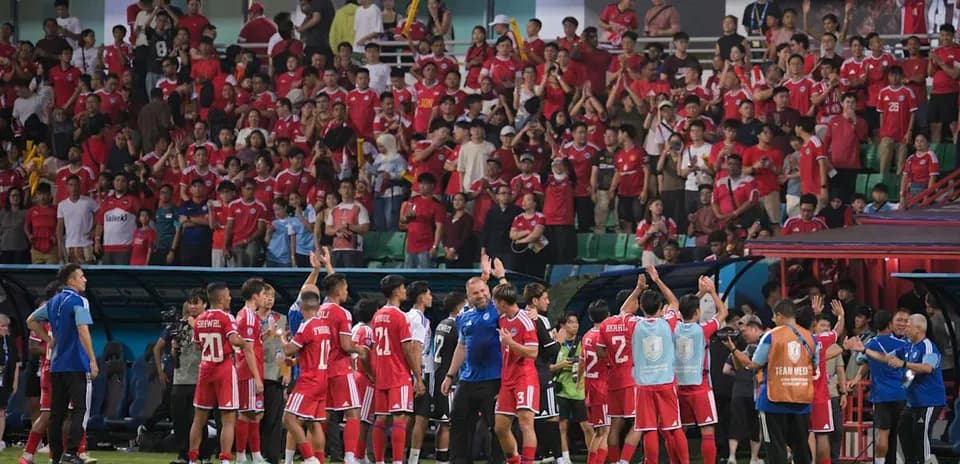 Football team celebrating with fans in stadium