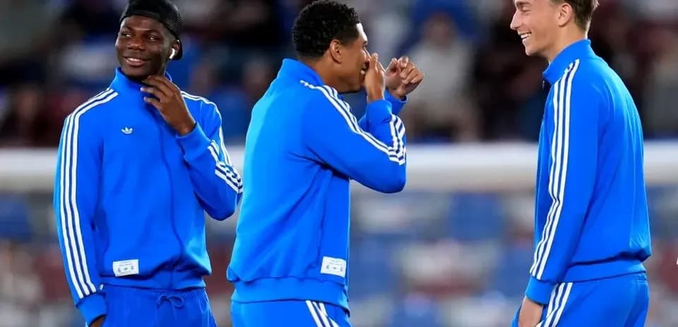 Three players in blue training gear chatting together