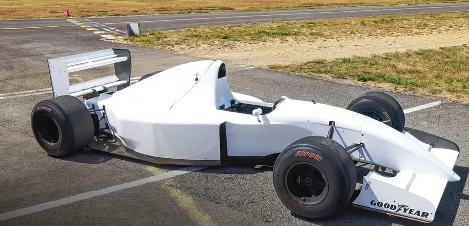White racing car parked on an airstrip