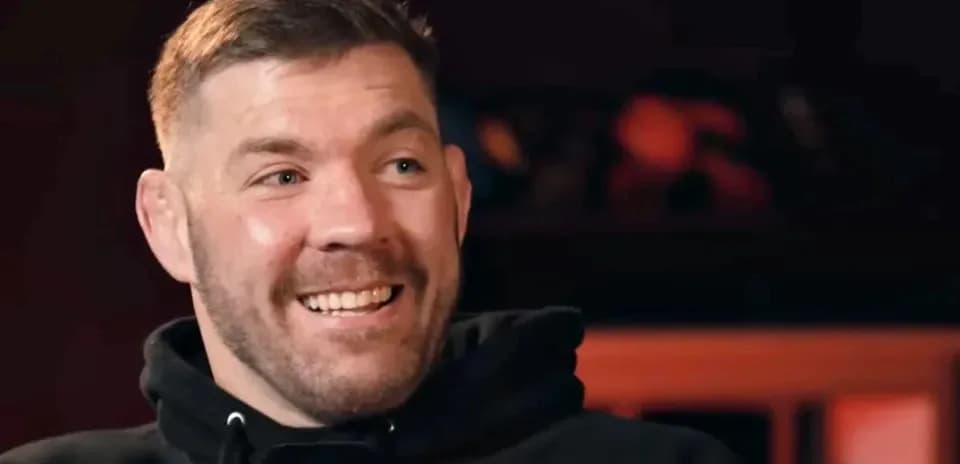 Man smiling while speaking into a microphone