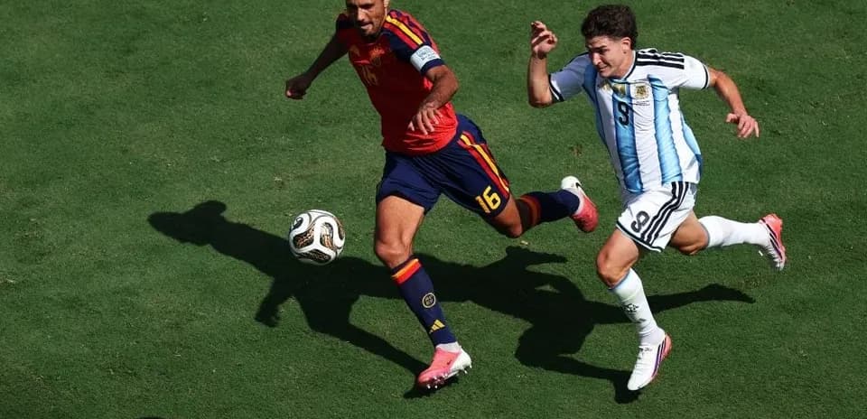 Ispaniya va Argentina o'yinchilari to'pni ta'qib qilmoqda