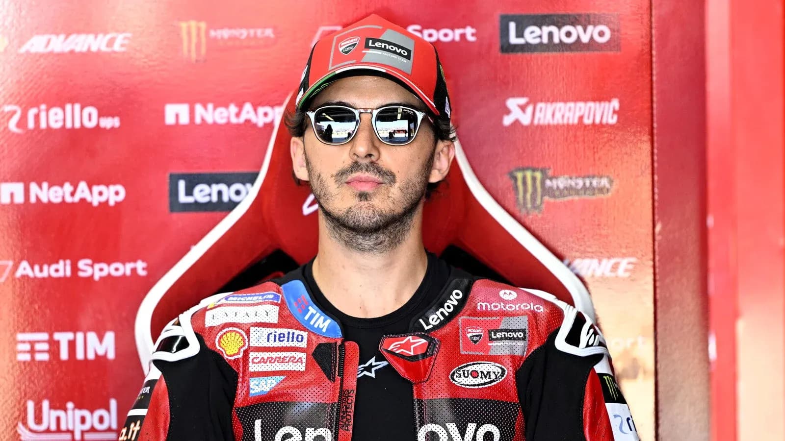 Rider in sunglasses seated in pit area