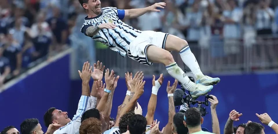 Lionel Messi being lifted by teammates after victory