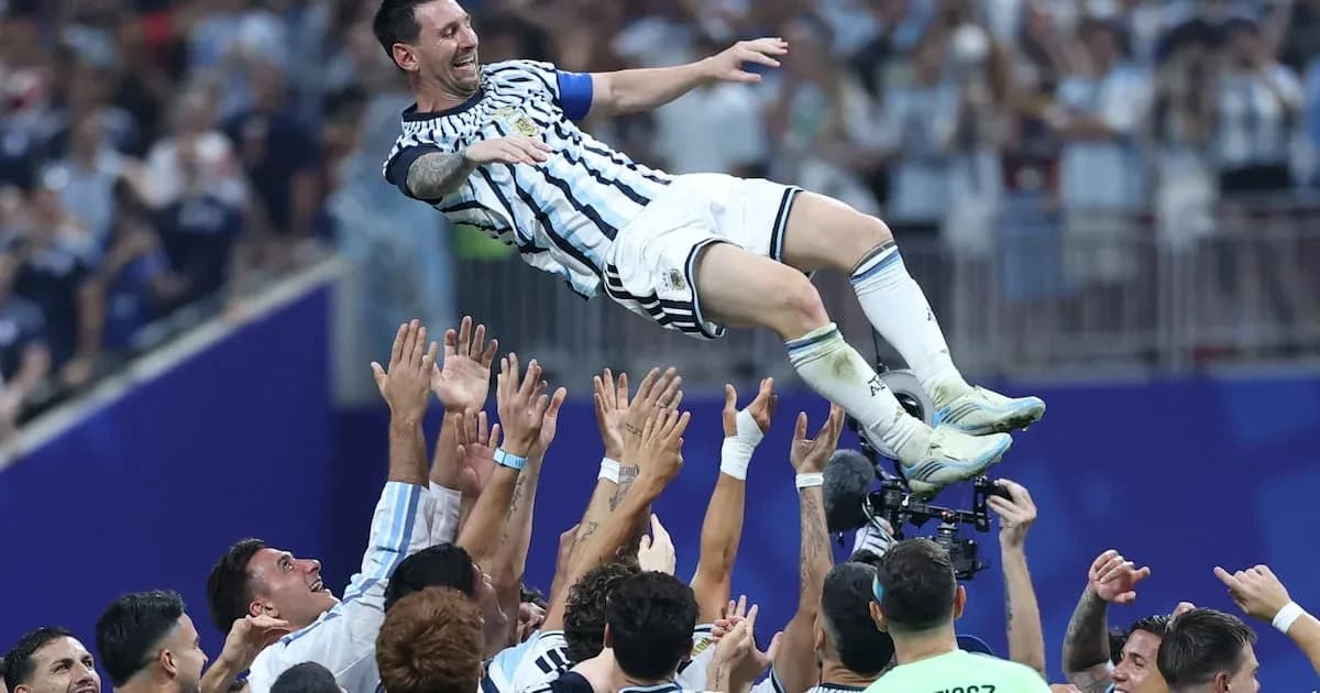 Lionel Messi being lifted by teammates after victory