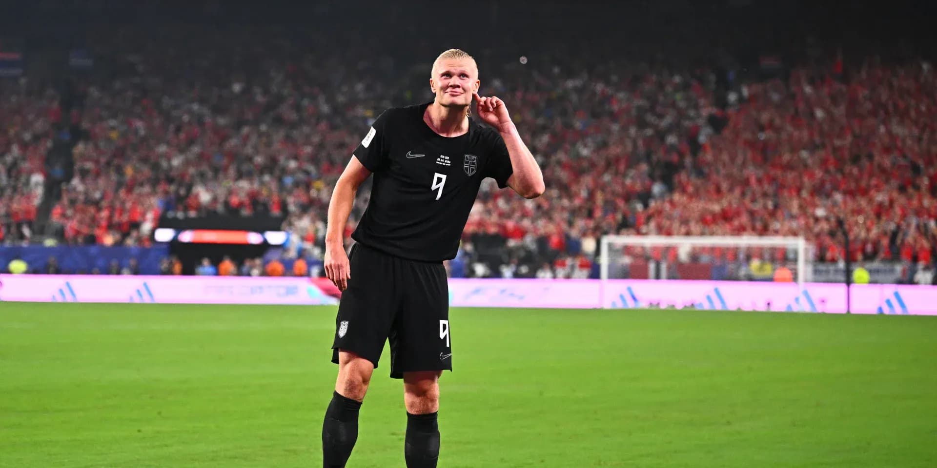Futbolchi maydonda qo'lini quloq tomon ko'taradi