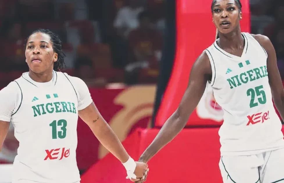 Two Nigerian basketball players holding hands on court