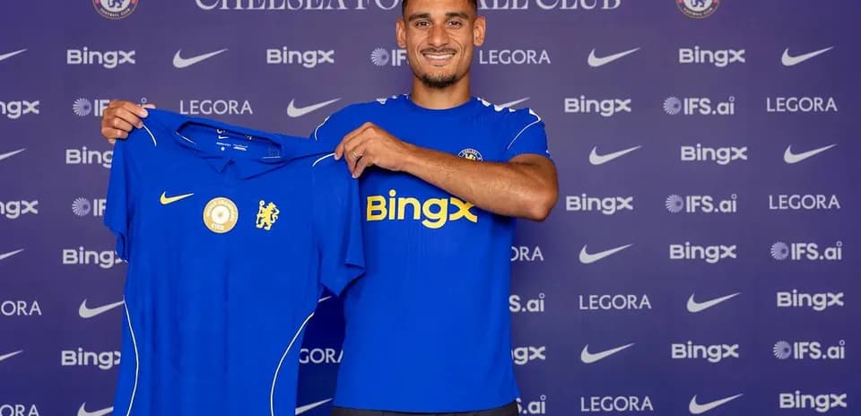Futbolchi Chelsea formasini ko'tarib turib turibdi