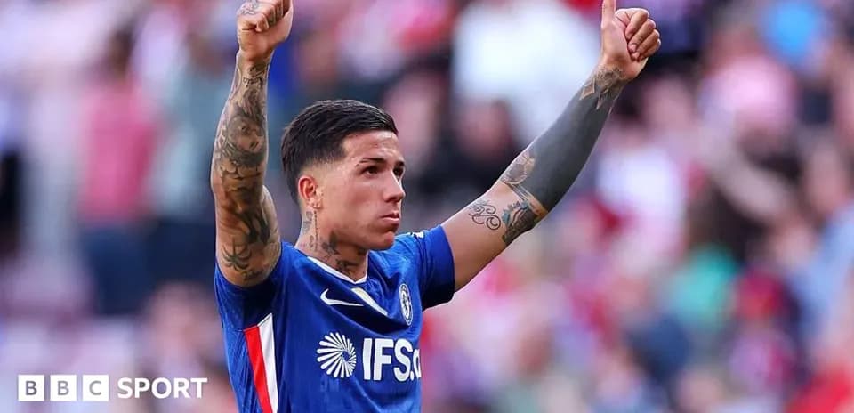 Futbolchi qo'lini ko'tarib, tomoshabinlarga salom bermoqda