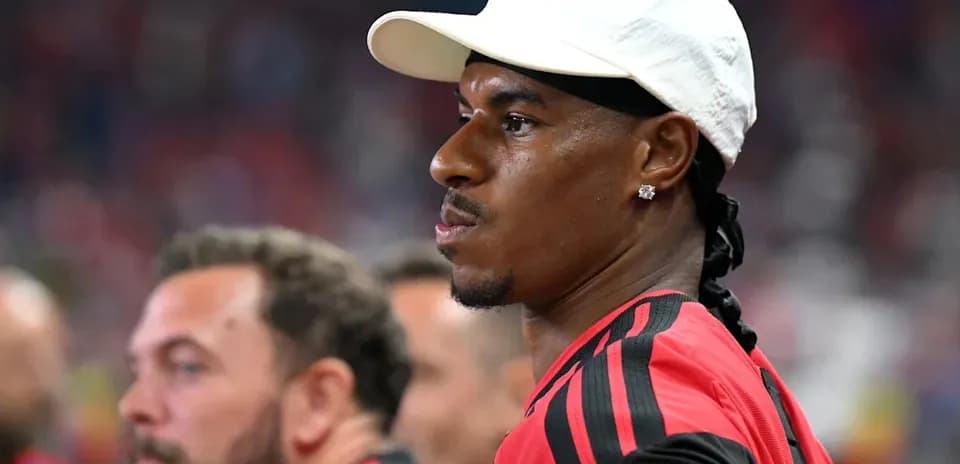 Futbolchi o'yin oldidan jamoa benchida turibdi
