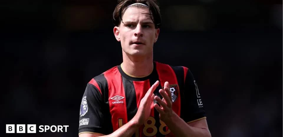 Futbolchi Bournemouth formasida maydonda qo'lini ko'taradi