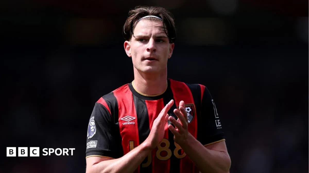 Futbolchi Bournemouth formasida maydonda qo'lini ko'taradi