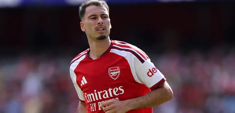 Futbolchi Arsenal formasi bilan maydonda yuribdi