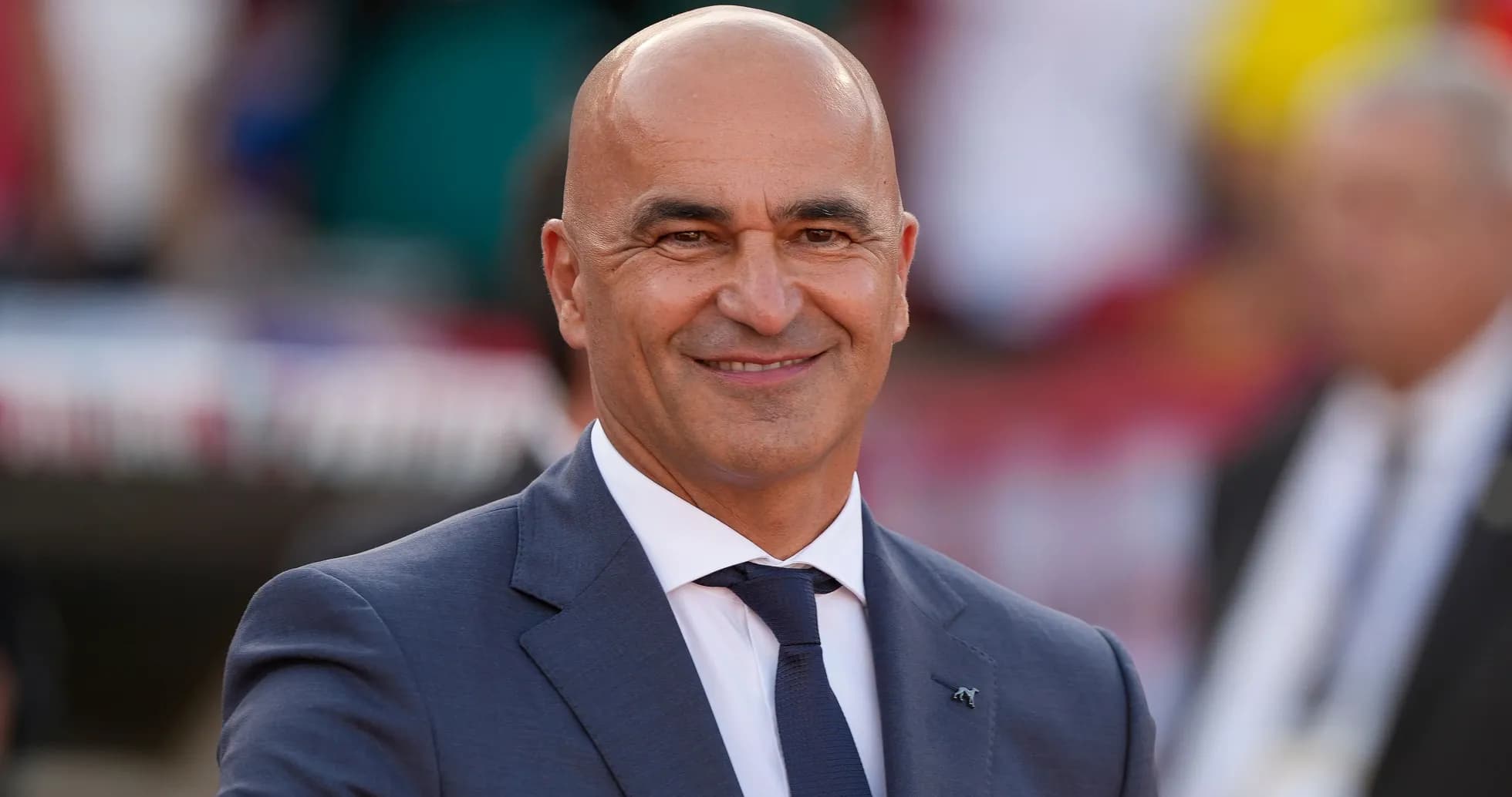 Bald man in suit smiling at event