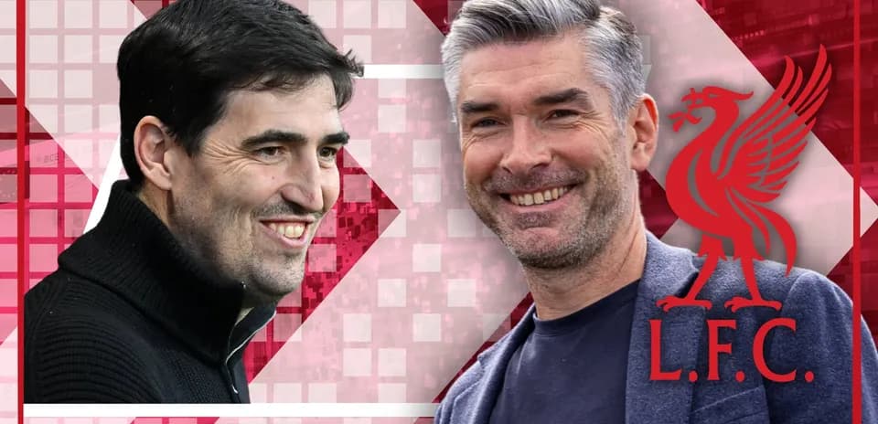 Two coaches smiling against Liverpool logo backdrop
