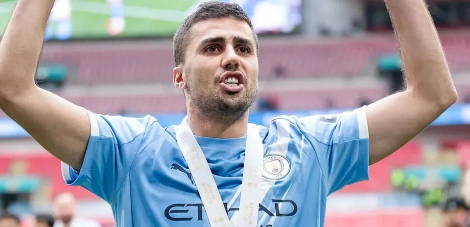 Futbolchi kubokni ko'tarib turgan holatda