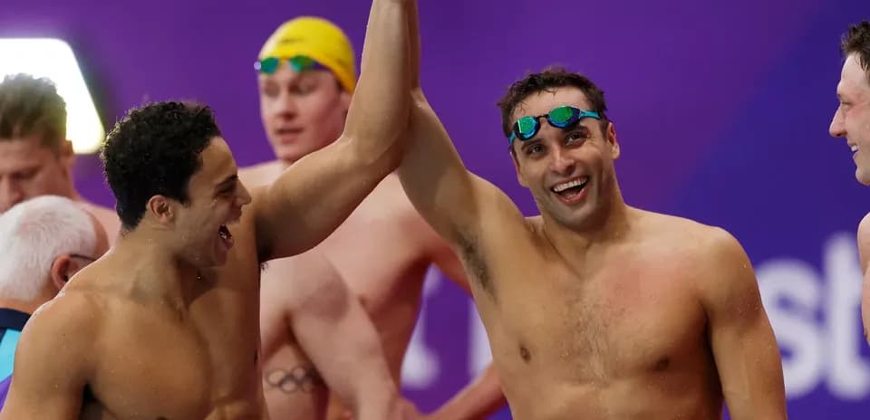 Two swimmers celebrating victory with raised arms