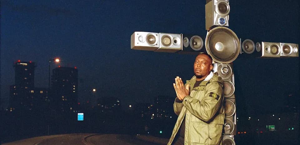 Man posing with large speakers at night