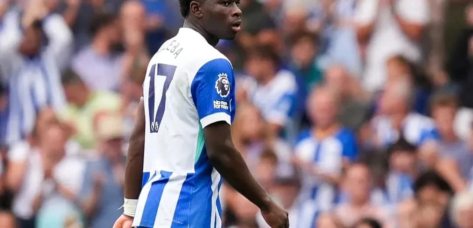 Futbolchi maydonda harakatda, tomoshabinlar ortida