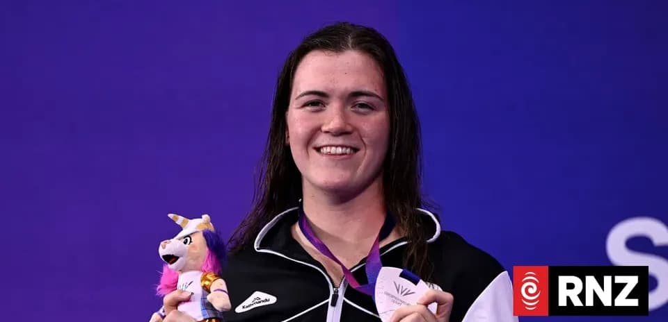 Sportsperson holding medal and toy on podium