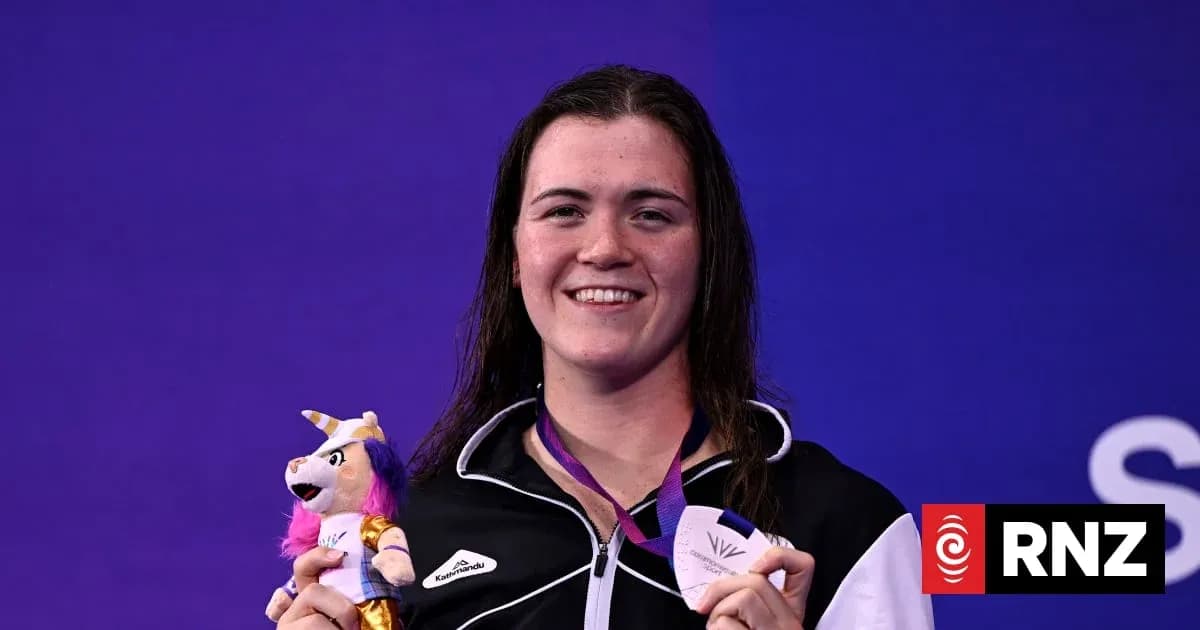 Sportsperson holding medal and toy on podium