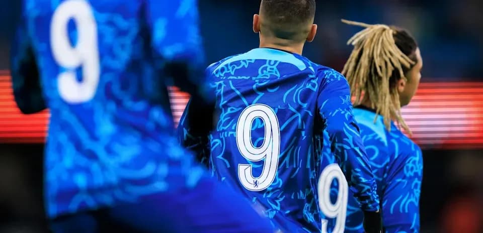 Futbolchilar ko'k formada, orqa tomondan raqami 9
